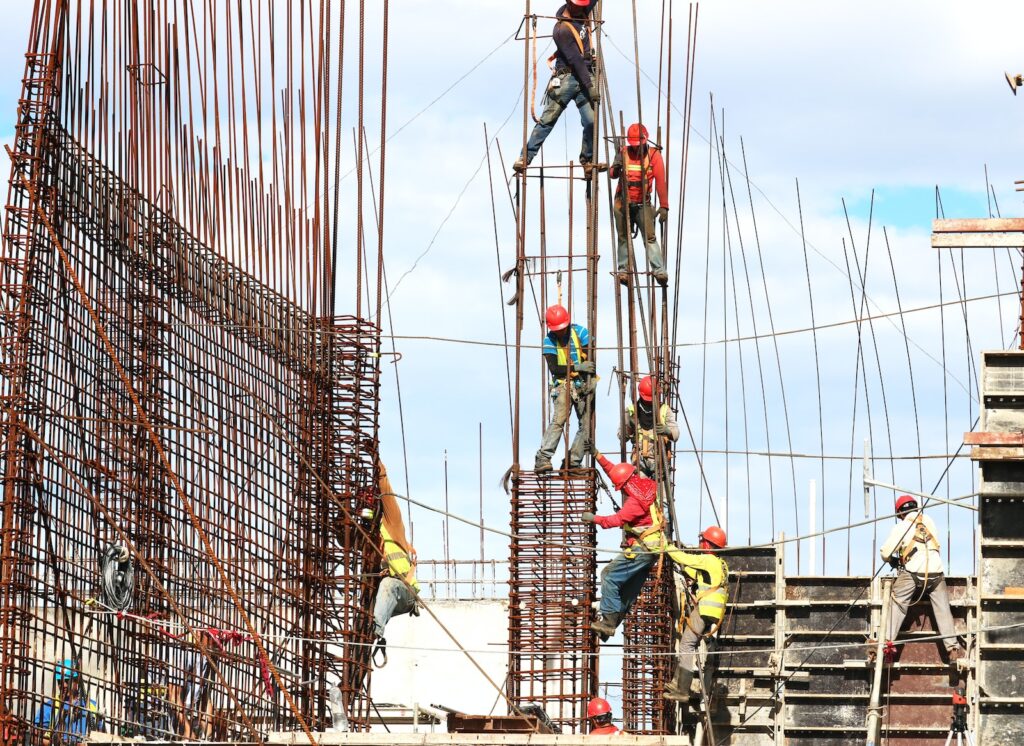 Construction workers building steel rod frame for a building