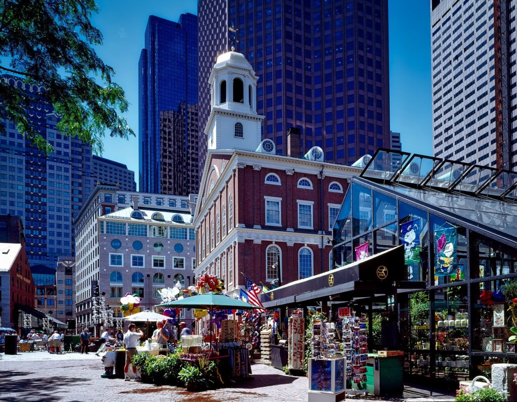 Man selling souvenirs outside Faneuil Hall on a sunny day.