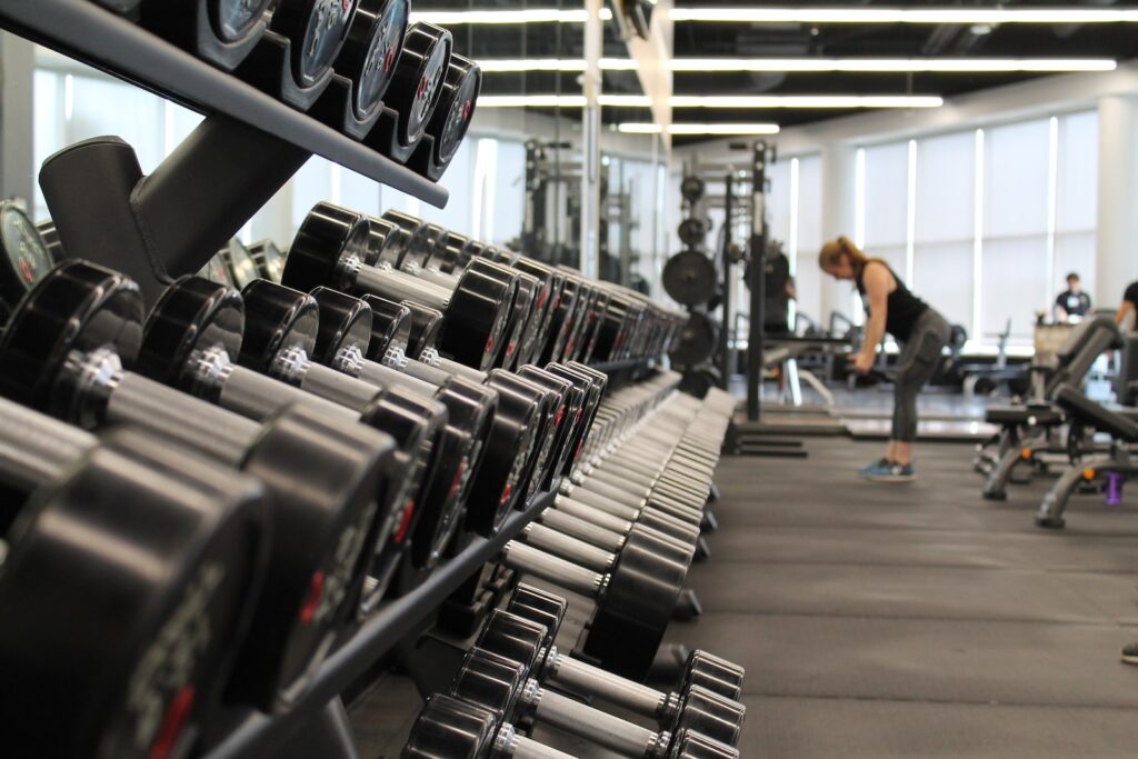 woman standing surrounded by dumbbell weights