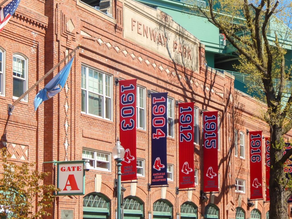 Fenway Park baseball stadium with Red Sox banners on building.