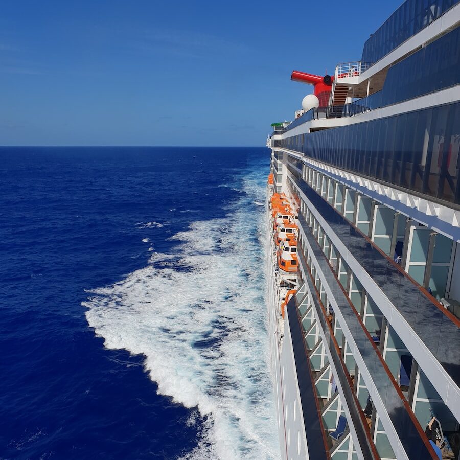 Side shot of a cruise ship with orange life boats