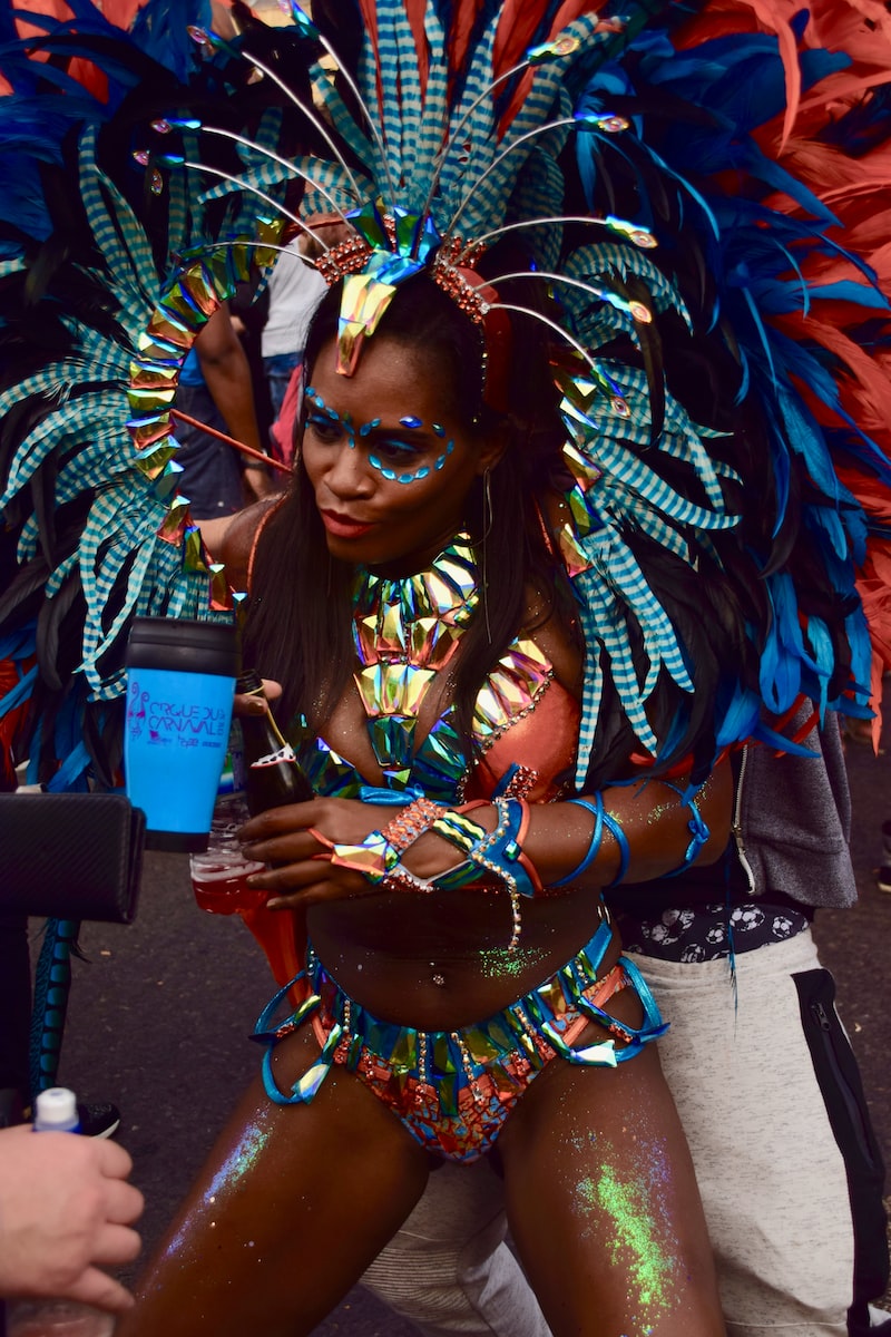 woman wearing blue feather headdress and jeweled orange costume 