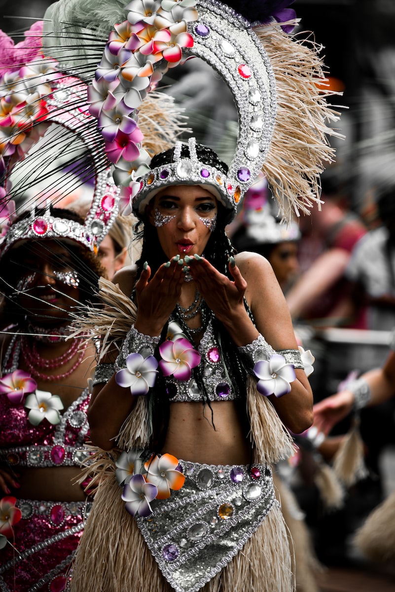 woman in white jeweled headdress and white jeweled costume with flowers