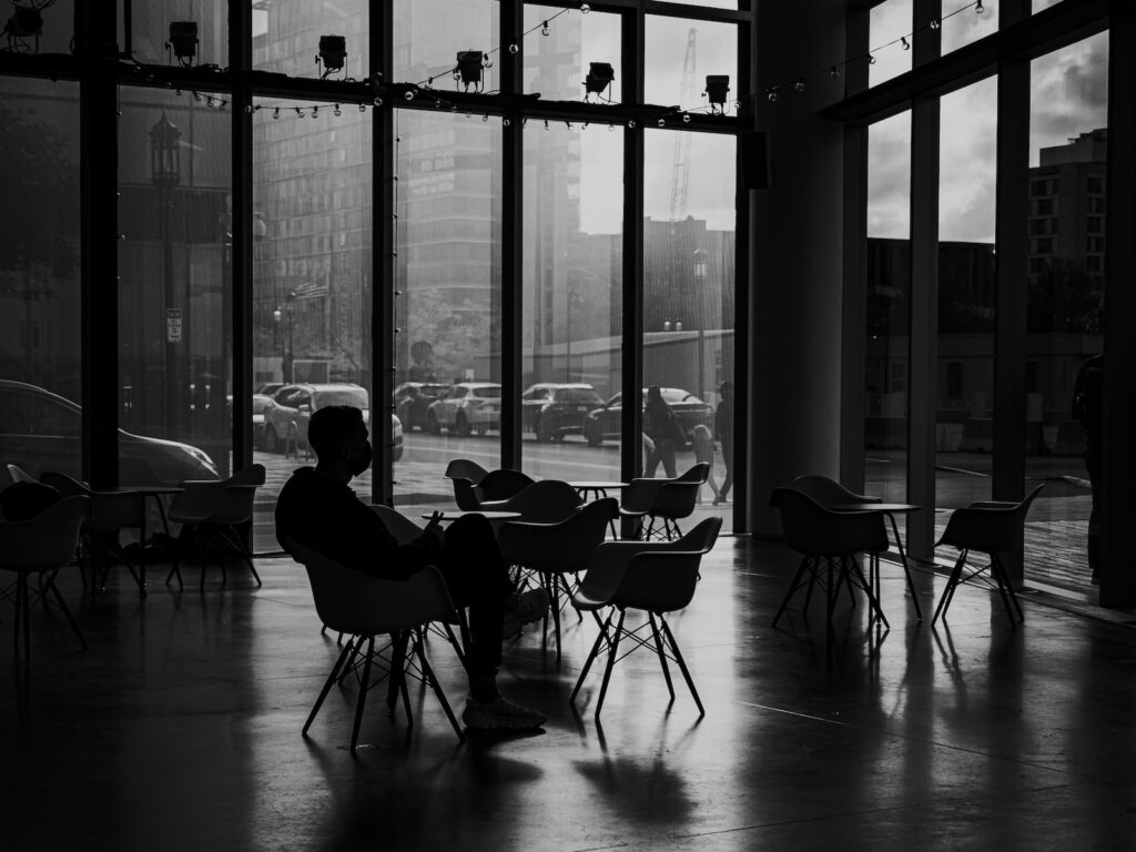 Black and white image of man sitting in lobby of the Institue of Contemporary Art in Boston. 