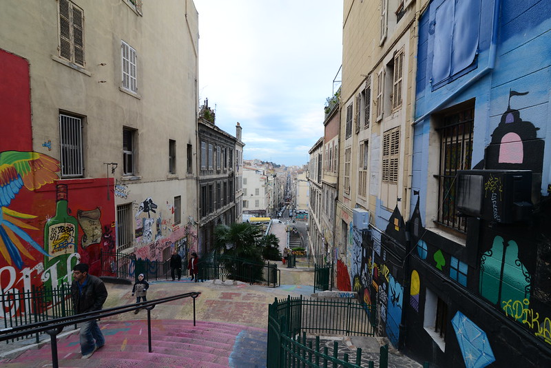 Colorful neighborhood in the historic center and cultural heart of Marseille. Displays buildings with murals on the walls.
