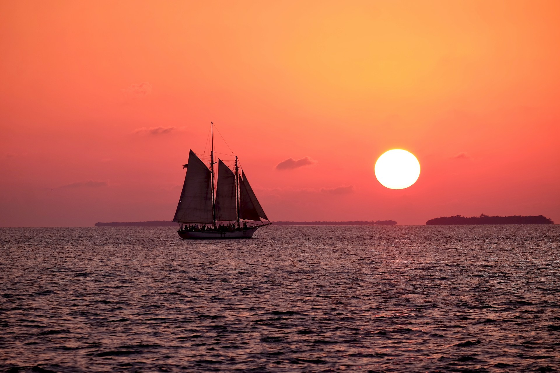 sailboat sailing through key west waters during the sunset