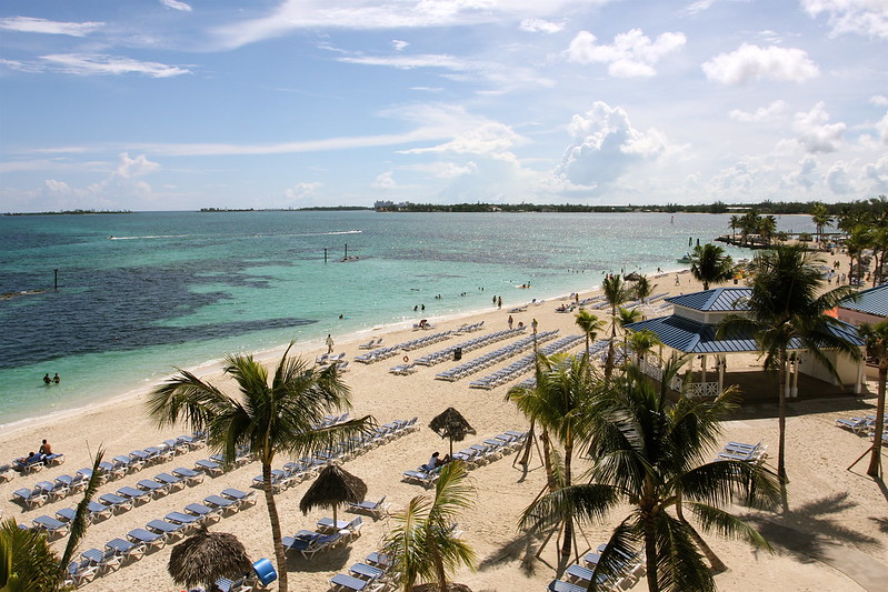 aerial view of chairs and umbrellas set up in front of the water at a beach in Nassau, Bahamas