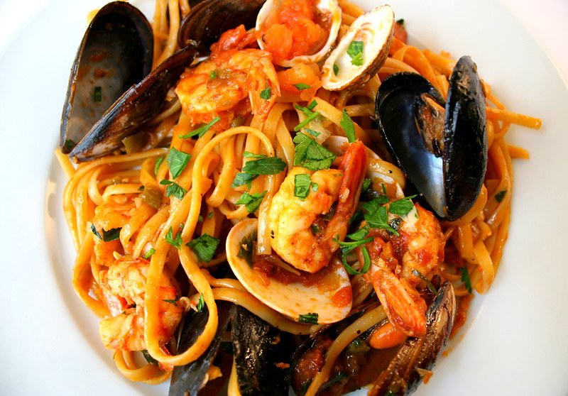 A typical seafood dish that would be served in Italy. Variety of seafood with pasta.