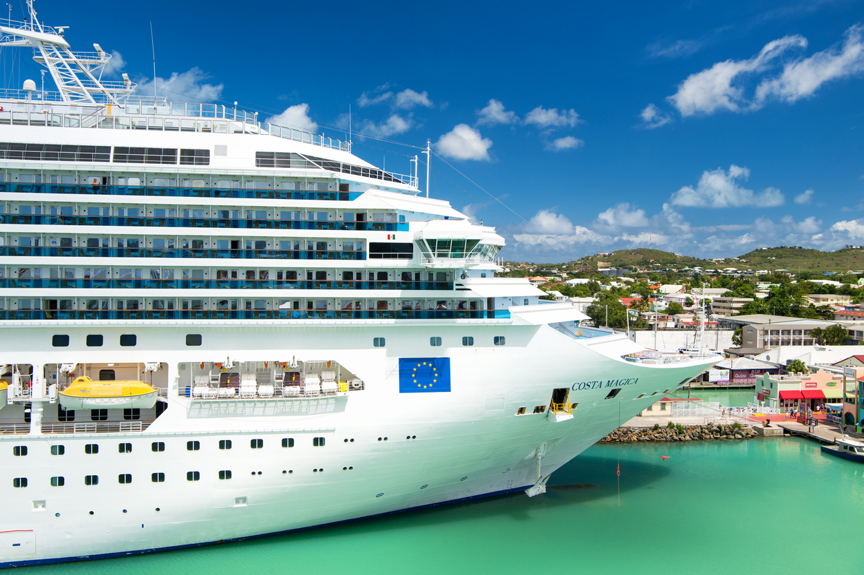 large cruise ship arriving to the Port of Antigua. Beautiful aqua colored waters and the city in the background. 