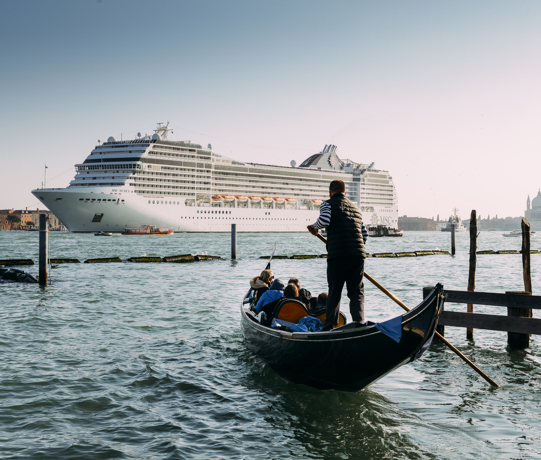 huge cruise ship in Giudecca Canal. gondola being guided with a paddle as people watch the cruise ship arrive
