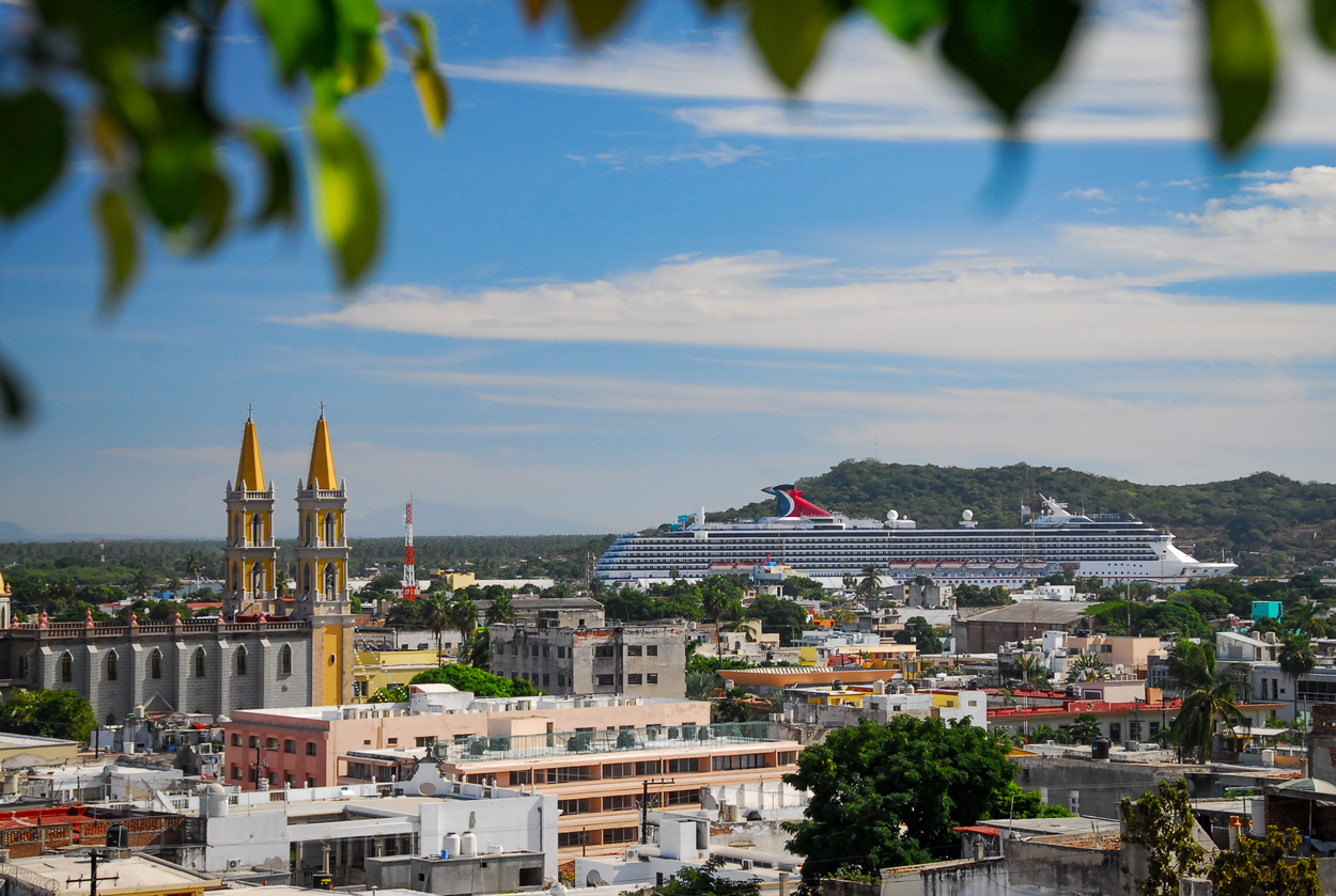 Downtown old Mazatlan seen from above with a church and cruise boat in the distance