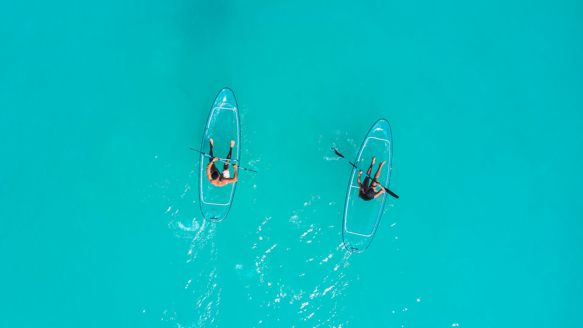 aerial view of two people on paddle-boards in the light blue waters of Grenada.