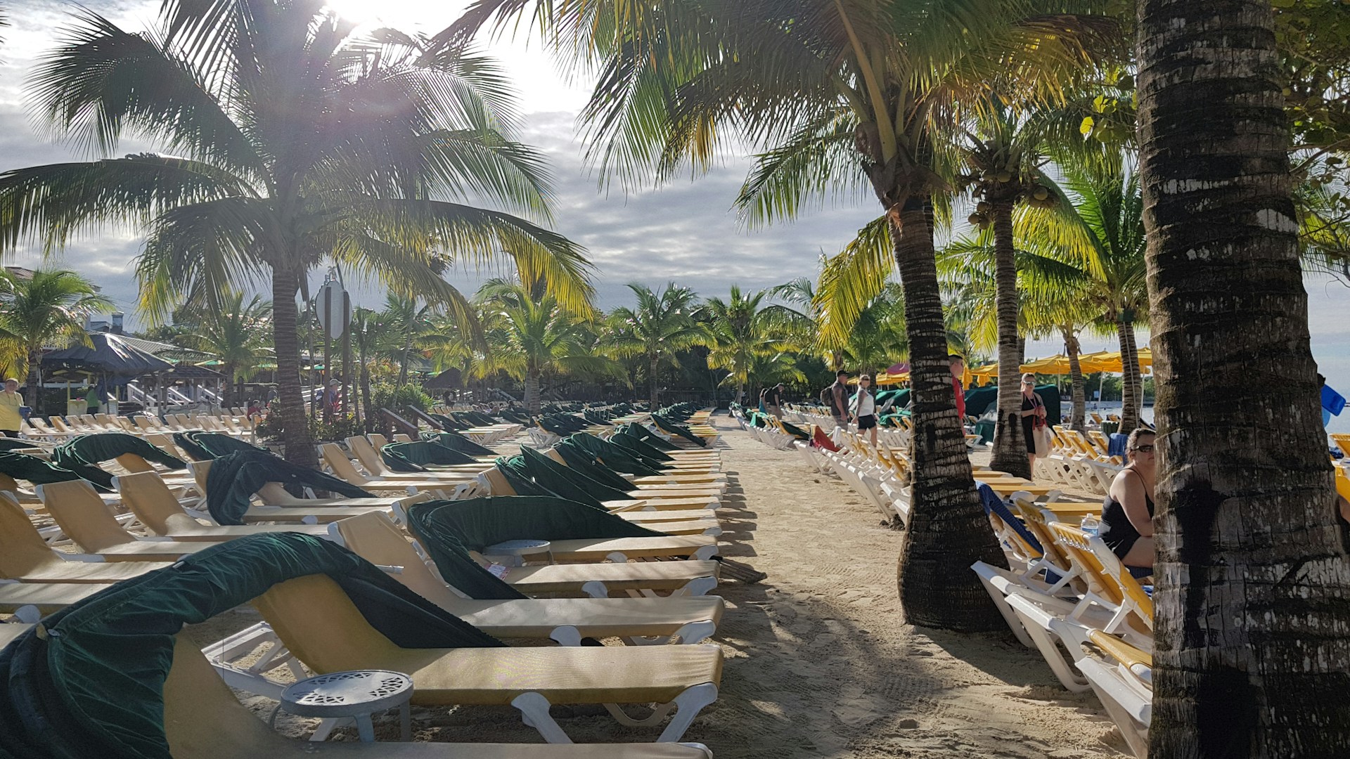 lots of beach chairs set up for guests facing the ocean at Mahogany Bay, Honduras.