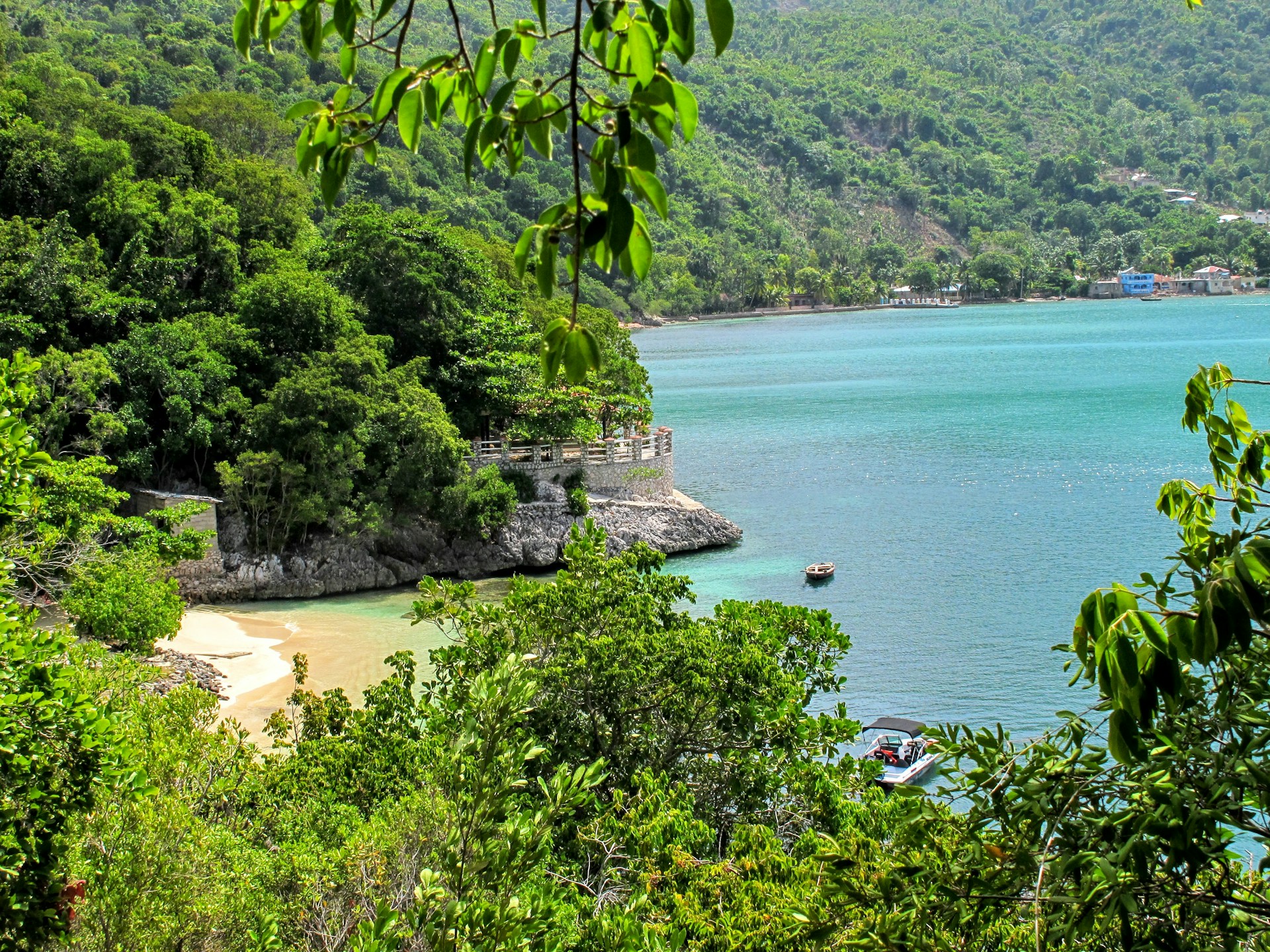 Beautiful view of  a small private beach in Labadee, Haiti with the ocean and big trees in the background.