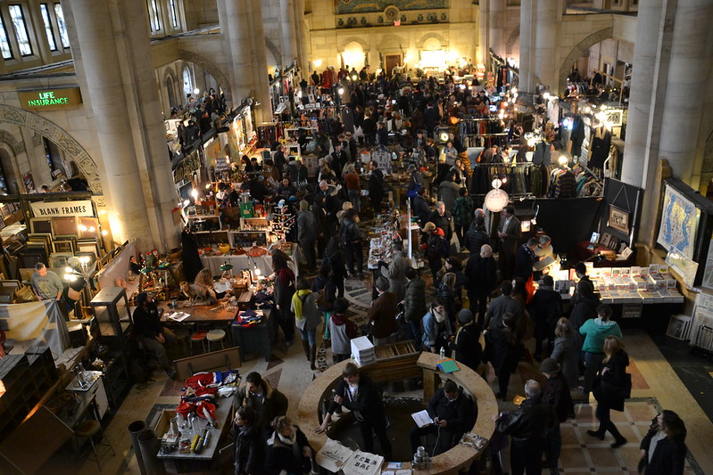 Aerial view of the crowded Brooklyn flea market with vendors and customers.