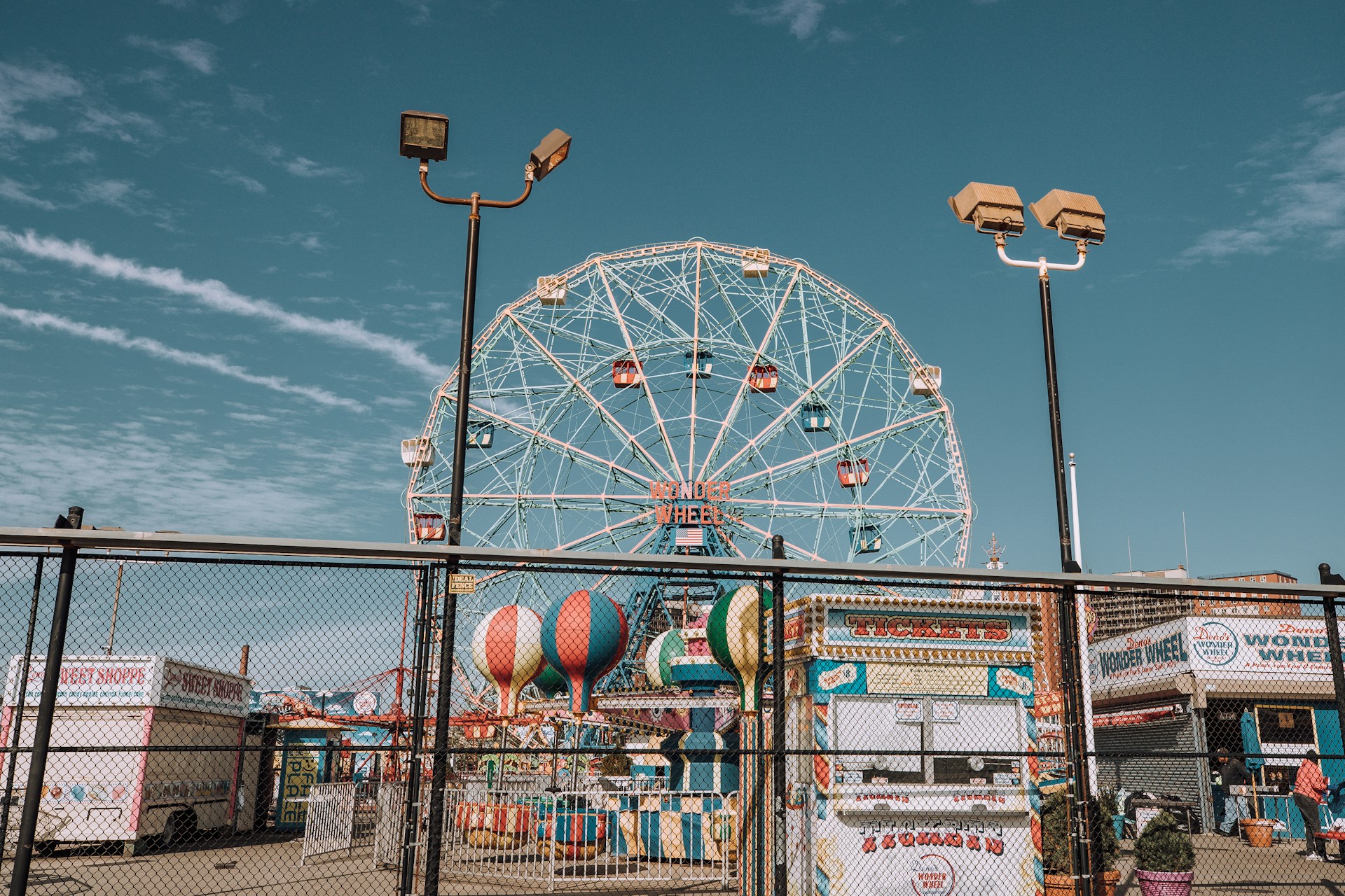 View of the amusement park, Coney island, in Brooklyn New York. Big Ferris Wheel and other stands visible.